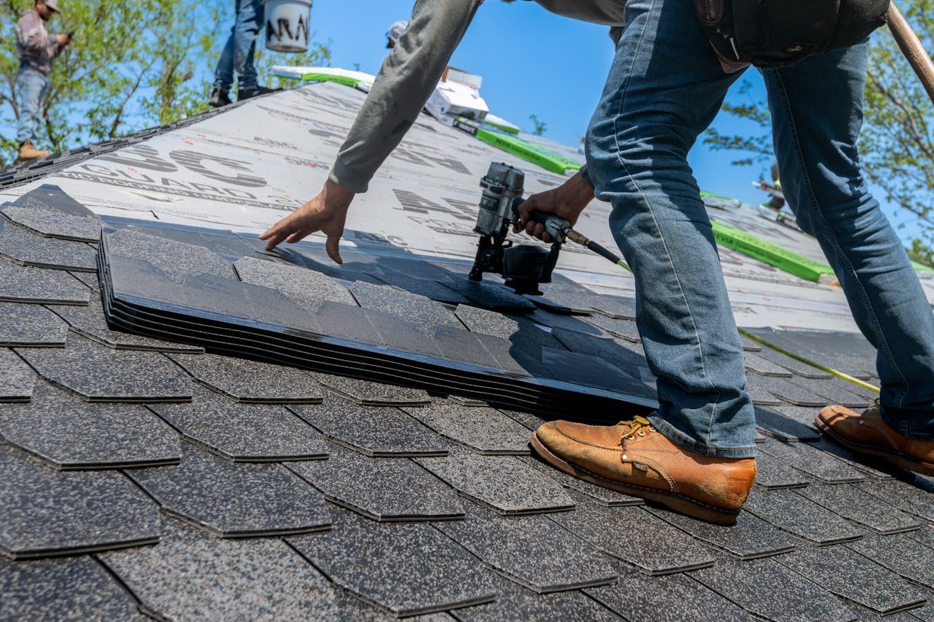 Roof replacement in progress on a brick home